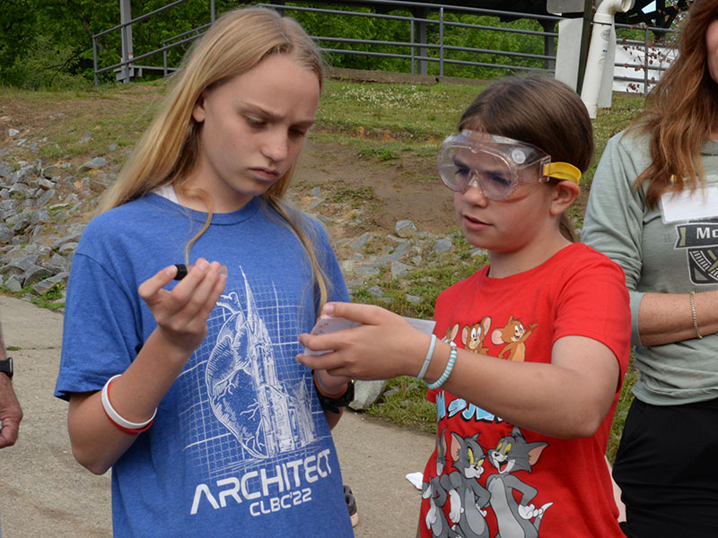 Jacquelyn Cline, left, and Jayden Collins tested the Toccoa River waters to make sure the water holding their rainbow trout was compatible for the tiny fish to be relocated. Both the temperature and PH levels of the two sites had to be compatible to safely move the fish.