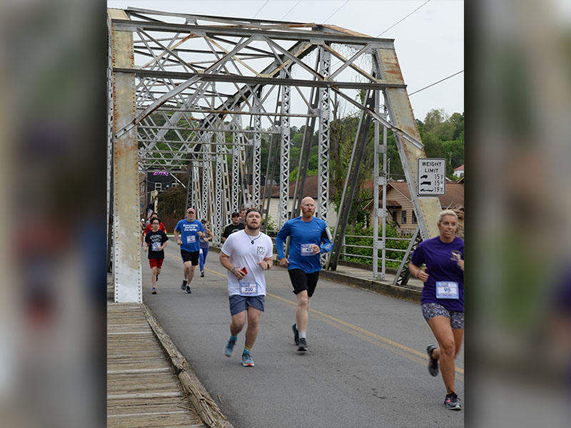 Runners cross the historic steel bridge in McCaysville that crosses the Toccoa River. The bridge is one of the scenic draws the race boasts.