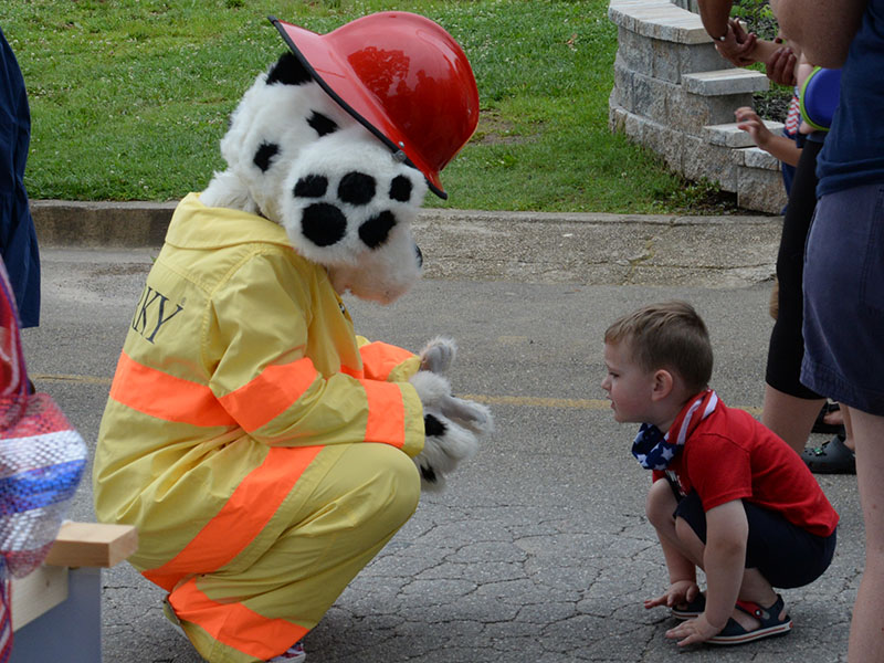 Smoky, the Fannin County Fire Department’s mascot, visited with this youngster before the start of the Old Timer’s Parade.