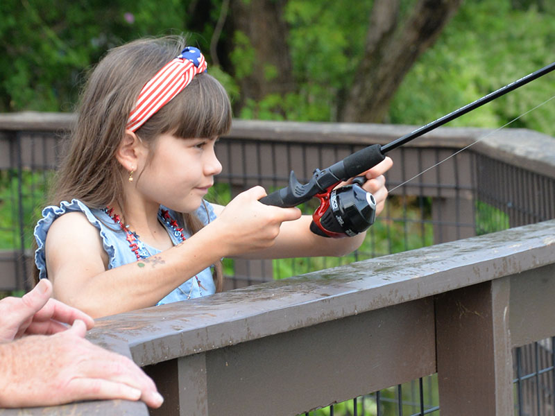 Olivia said she was determined to catch more fish than the boys when she took part in the Fishing Rodeo that kicked off the Independence Day celebration in McCaysville Saturday, July 1. She is shown trying her luck from the deck overlooking the Toccoa River at the Toccoa River Park. The rodeo was followed by free hotdogs, chips and drinks for everyone. A parade and antique car show took place in the afternoon before the annual fireworks display that night.