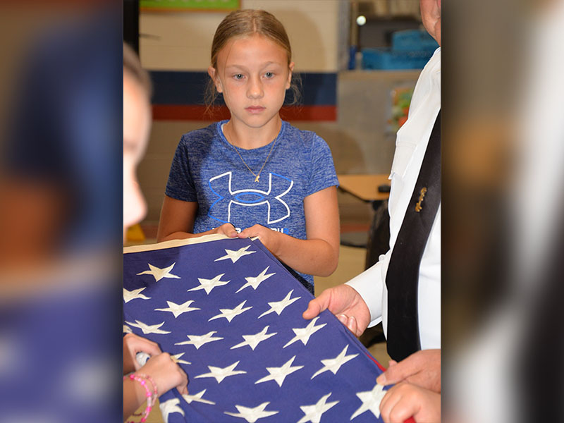 Alexandria Evans pays close attention as she learns how to properly fold a United States flag. Each year members of Fannin County veterans groups visit fifth grade classes to present a program on flag etiquette.