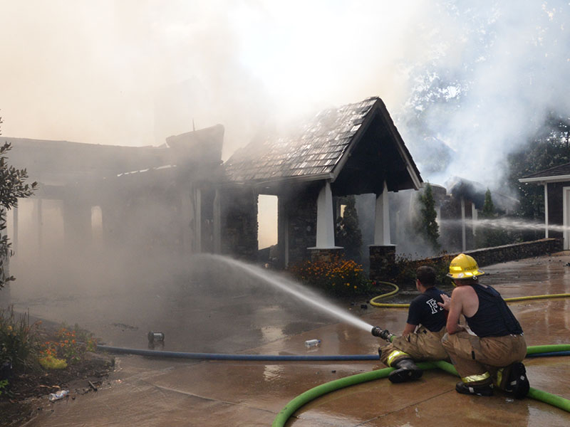 Firefighters battled extreme heat Wednesday, July 26, when they fought a fire at a Blue Ridge Lake home. Despite how close the home was to a garage, at right, and another residence, only the garage suffered very minor damage with a melted gutter