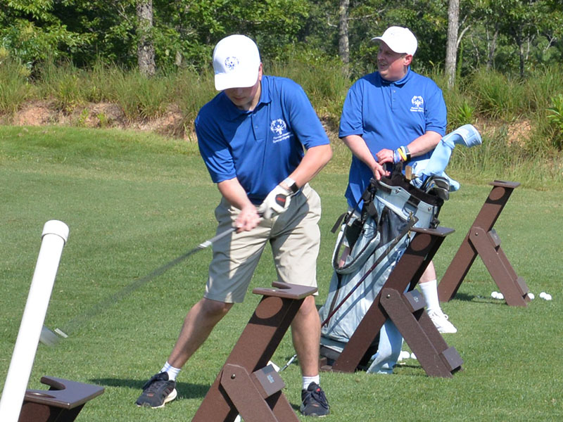 Alex Hughes and Eric Morris are determined to hit their golf balls farther than any other competitor in the Special Olympics Golf Skills Event at Old Toccoa Farm.