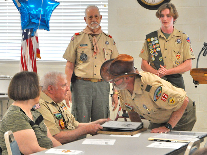 Larry Dyer and Troop 32 Scoutmaster David Lewis converse over the awards presented to Dyer at the celebration. Mathew Monroe, Senior Patrol Leader of Troop 32, presented the awards to Mr. Dyer.