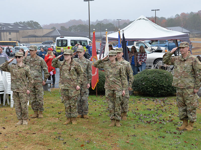Members of the Christian Junior Reserve Officer Training Corps (CJROTC) at Mountain Area Christian Academy salute during the ceremony Saturday at Veterans Memorial Park in Blue Ridge. Shown are, from left, front, Senior Airman Alyha Hawkins, Airman Rebekah Pickelsimer, Airman Beverly Sanders, CJROTC Instructor TSgt. John Tucker; and, back, Airman First Class Jacob Corley, Airman Maxwell Scott, and Staff Sergeant Lev Brovko.