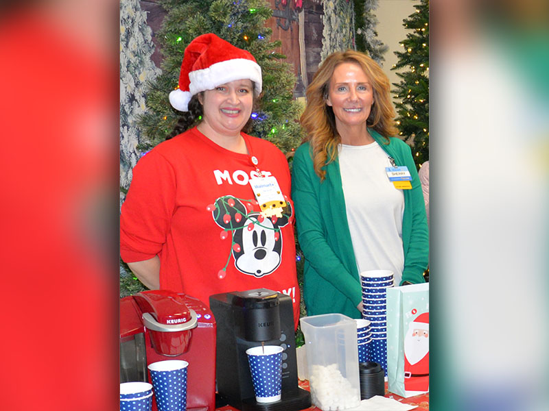 Walmart employee Amber Chadwick, left, and store Manager Sherry Neal served hot chocolate and snacks to Shop With A Cop participants.