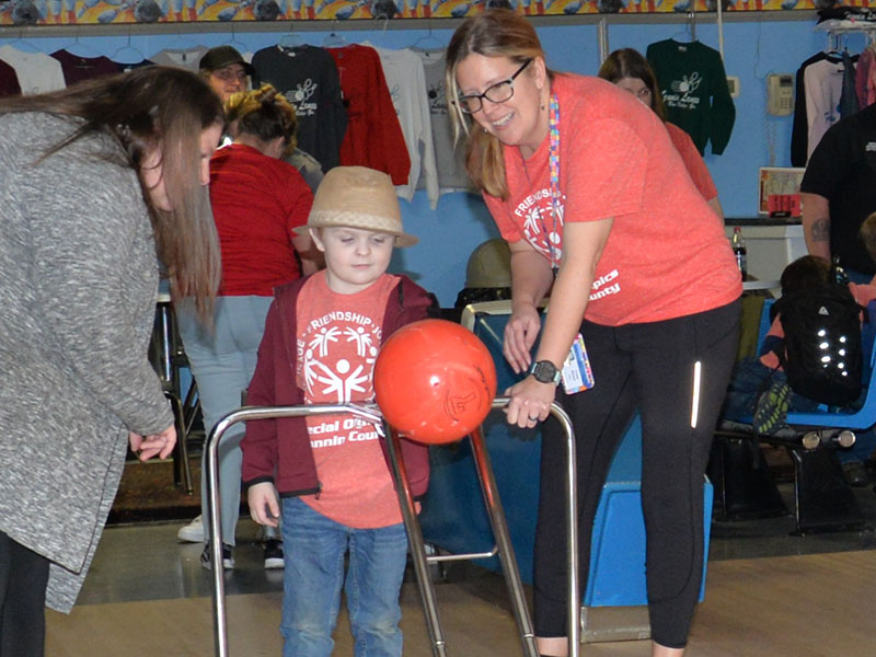 Maxwell Brown gets help from Mrs. Burner as they carefully work together to line up his next attempt during Special Olympics bowling.