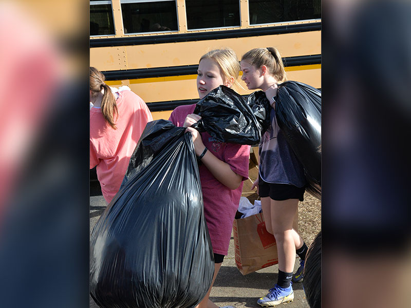 Karleigh-Jayne Stiles and Lillie Williams load bags almost as big as they are as part of students efforts to help the homeless.