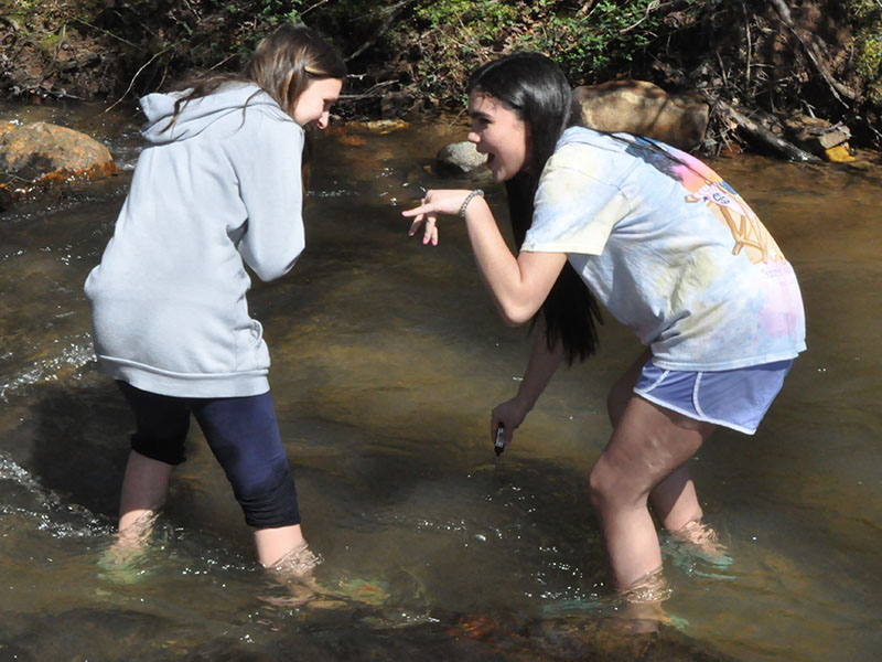 Students, left, Isabella Davenport and Selena Bell checked the temperature of the water to ensure their trout will be acclimated accurately.