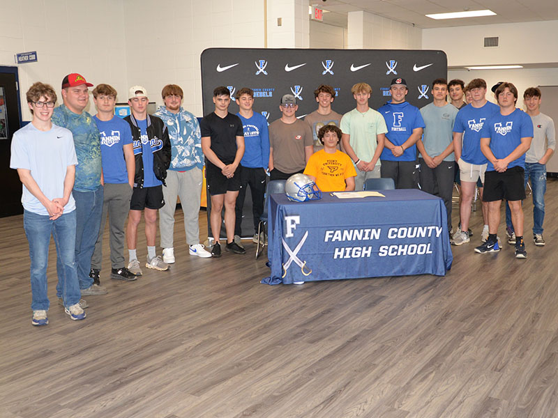 Several members of the Fannin County Rebel football team showed up to support Brody Paskill, seated, when he signed his Letter of Intent to play football at Point University. Players there to congratulate Paskill were, from left, Castle Barnett, Isaiah Stephens, Nate O’Neal, Baylor Twiggs, Scott Waldrep, Braxton Cheatham, Barron Davenport, Brayden Taylor, Judah Wood, Case Holloway, John Holsonback, Luke Holsonback, Andrew Nuckolls, Noah Burnette, CJ Reece and Matthew Ponton. Paskill also received an academi