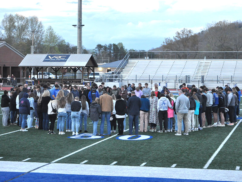 A large group gathers around Hunter Satterfield as he begins the candlelight vigil to offer prayers and thoughts for the Holsonback family with an opening prayer. The vigil was held on the Fannin County High School football field last week to remember the death of John Holsonback, the injuries to his siblings, and to lift up the entire family.