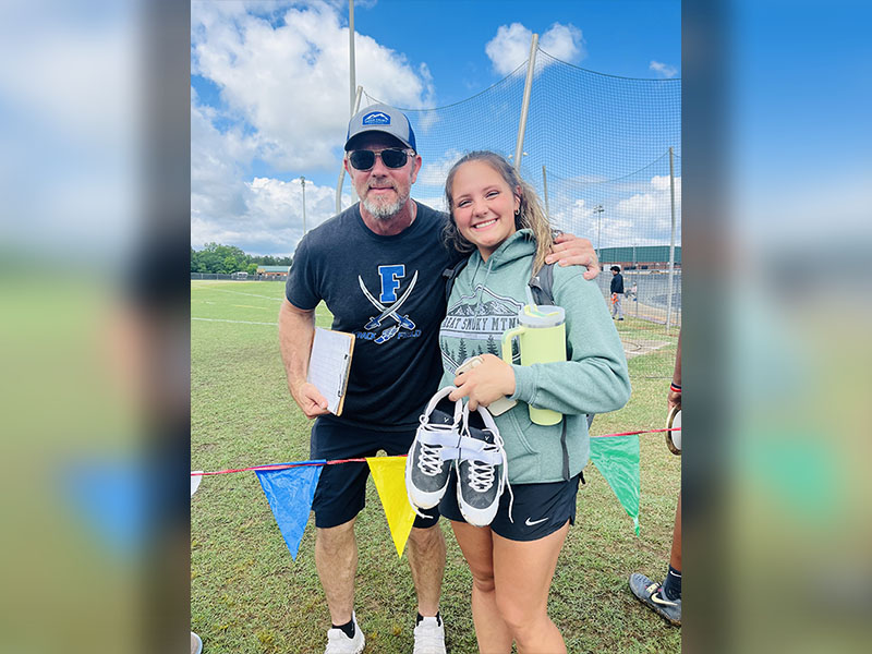 RICHT: Sydney German is shown with Throwing Coach Jeff Kuma at the Track & Field Sectionals Meet. German placed eighth in the Shot Put, earning her the right to compete in the State Championships.