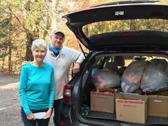 The Craddock Center volunteers Milly and Steve Hastings pack their car in preparation of delivering knitted hats and new books to children Friday, November 13.