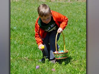 West Fannin Elementary School Pre-K student Gunnar Westphal picks up an Easter egg during the hunt orchestrated by the Fannin County High School Key Club.