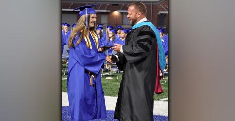 With the shake of hands, Isobella Dilbeck happily accepts her diploma from Fannin County High School 2021-22 Principal Dr. Scott Ramsey.
