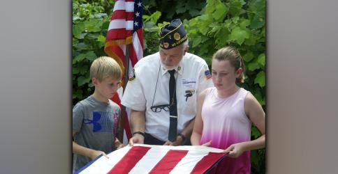 North Georgia Honor Guard member Steve Strickland helps Blue Ridge Elementary School fifth grade students Jayden Richardson, left, and Addyson Bradburn fold the American flag during a Flag Etiquette class at the school Friday, August 27.