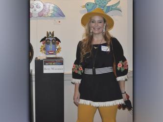 The Blue Ridge Mountains Arts Association held their opening reception for the Contemporary Southern Folk Art exhibit Saturday, September 4. Artist Kristen Ramsey presented her pieces  that are shown hanging on the wall behind her, which she cuts and carves designs out of plywood and paints with enamel. 