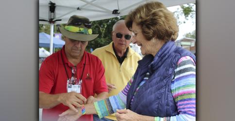 Greg Arnold, with the Blue Ridge Business Association, welcomes B.J. Martin, of Blue Ridge, to the Arts in the Park weekend Saturday, October 9. Also shown, waiting in line is David Mulder. 