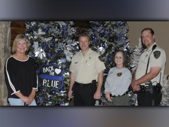 Serenity in the Mountains owner Linda Cole, left, and her staff are once again hosting the Tour of Trees to benefit the Fannin County Shop With A Cop program. Shown with her in front of the “Back the Blue” tree are, from left, Sheriff Dane Kirby, coroner and Shop With a Cop Treasurer Becky Callihan, and deputy sheriff and Shop With a Cop committee member Jim Burrell.