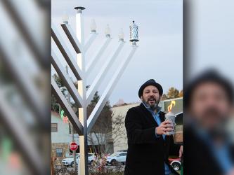 Charlie Chasen led the crowd in three blessings before and during the lighting of the first candle in observance of the first night of Hanukkah.   