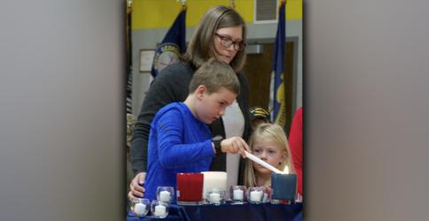 Connor Owens lights a blue candle in remembrance of the veterans who sacrificed it all during West Fannin Elementary School’s Veteran’s Day Program Friday, November 12. He is shown with mother Brooke and sister Reagan.