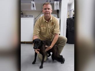 This cutie is a female lab mix who was picked up in Mineral Bluff. She has a solid black coat. View this pupper using intake number 114-22. She is shown with Animal Control Officer Luke McDonald.