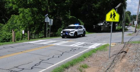 McCaysville police officers are promising strict enforcement of the 25 miles-per-hour speed limit in the area of the new crosswalk on Toccoa Avenue/Highway 60 in front of Rolling Thunder River Company. This is the site, shown above, where a ten-year-old boy was killed as he attempted to cross the highway in 2013. With the river tubing season in full swing, the area is congested with traffic and pedestrians.