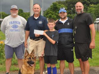 Ten-year-old Clay Maddox presents his $1,000 donation to Fannin County Recreation Department representatives to help pay fees for children who would like to play sports but cannot afford to register. Shown are, from left, John Spargo, Eddie O’Neal, Clay Maddox, Tim Towe, Earl Maddox and, in front, Clay’s dog Maverick. 
