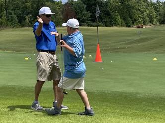 Special Olympics Golf Coach and Coordinator Craig Hartman, left, cheers for athlete Jay Jenkins, right, at Old Toccoa Farm Tuesday, July 19.