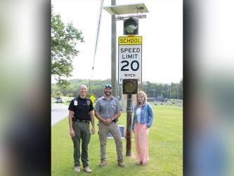 Lieutenant Darvin Couch, Blue Ridge Street Department Supervisor Tony Byrd, and Blue Ridge Mayor Rhonda Haight are shown with the new school zone warning lights in front of Fannin County Middle School. The city paid for the safety improvement.