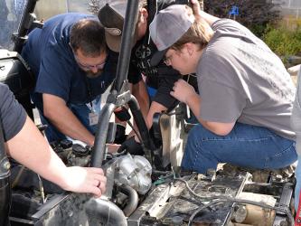 Automotive Technology instructor Daven Dilbeck helps Dakota Rutledge and Drew McDaris who was working with a team of Automotive 1 students to find why a four-wheeler would not start.