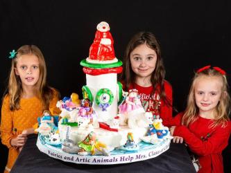 The “Glitter Girls” took third place in the Child Division of the National Gingerbread Competition in Asheville, North Carolina. Their creation showcased Mrs. Claus and her Arctic friends. Shown, from left, are Sarah Miller, Violet Lake, and Bryna Thompson.