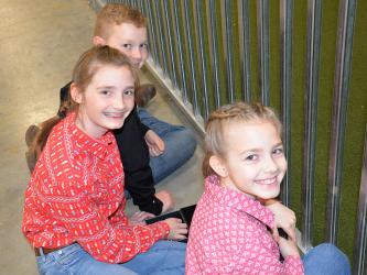 Owen Norton, Lola Temples and Ana Temples, back to front, are all smiles as they take a break between classes at the Pigs on the Ridge Invitational Market Hog Show last week at the Fannin County Agriculture Facility. All three of the youngsters came away from the show with honors.