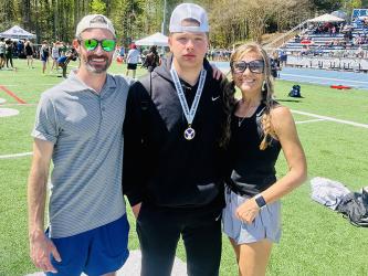 Senior Matthew Crowder, center, placed third in shot put at the Marietta High School Spring Break Invitational. Crowder is pictured with Coach Lucas Roof, left, and Head Coach Miranda Roof, right. 