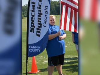 manda King holds the United States flag during the opening ceremony for Special Olympic Golf Skills Event Tuesday morning, July 25, at Old Toccoa Farm.