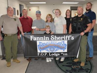 Skylar and Riley Gazaway received proceeds from the Corporal Richard Gazaway Memorial Golf Tournament last week. Shown during the presentation of the check at the Fannin County Sheriff’s Office are, from left, Investigations Sergeant J.K. Davenport, Sheriff Dane Kirby, Wayne Stover accepting the donation for the children, Riley Gazaway, Glenda Stover, Skylar Gazaway, Investigator Erin Sehl, Sergeant Jacob Pless and Investigator Dustin Carder.