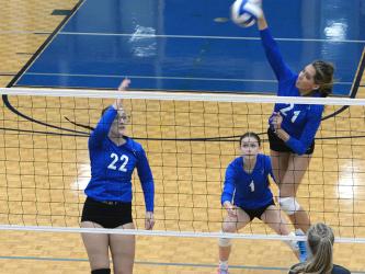 Peyton Slone looks for a kill while Karis McIver and Kaylie Davenport watch for the opponents’ next play in recent volleyball action.