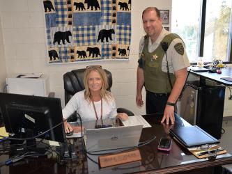 Fannin County deputy sheriff and school resource officer Jim Burrell looks over some of the new technology being installed by Brandi Holloway at Blue Ridge Elementary School.