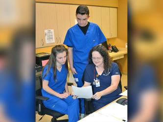 Students Blair Deal and Trent Davis look over a patient’s chart with LPN Candy Burgess at Georgia Mountains Health. The two students are juniors at Fannin County High School and are a part of the General Medicine class’ clinical rotation program. 