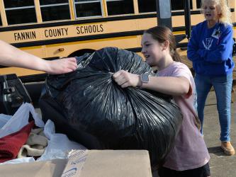 Fannin County Middle School (FCMS) student Lennox Patterson loads a bag filled with items to help Fannin County’s homeless population into the back of a pickup truck. FCMS students collected over 4,000 items in a school wide competition.